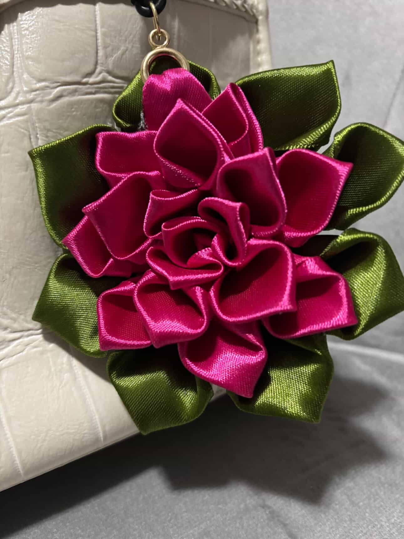 Hot pink ribbon flower keychain on a handbag